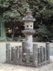 周りは円筒形の石塔で囲まれ中心に石燈籠が立っている写真