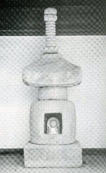 相輪、屋根、頸、軸部、基壇の五部でできており真ん中にお地蔵様がいる石造宝塔の写真