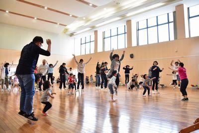 参加者たちが両手を挙げてジャンプをしている写真