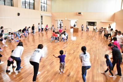 子供たちと保護者で大きな円を作り、中央には複数の子供たちが集まっている写真