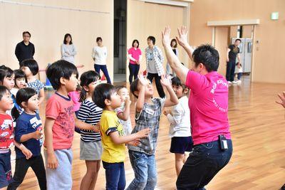 順番に並んでスタッフとハイタッチをしている子供たちの写真