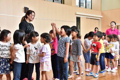 2列に並び隣同志になった子供たち同士で手をつないでいる写真