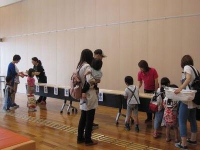 参加者達が長机の前で受付をしている写真