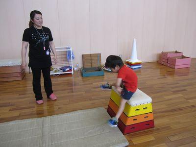 男の子が3段の跳び箱を跳び越えようとしている写真