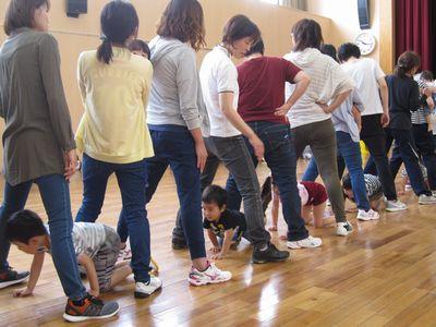保護者の方が1列に並び足を広げて出来たトンネルの中を子供たちが通っている写真