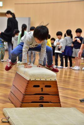 男の子が3段の跳び箱を跳んでいる写真