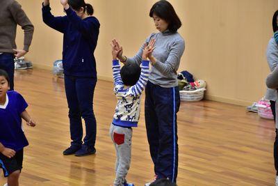女性と男の子が立ってハイタッチをしている写真