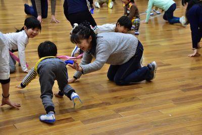 女性や子供たちが四つん這いになってはちまきを取ろうとしている写真