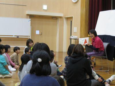 絵本の読み聞かせを聞いている参加者達の写真