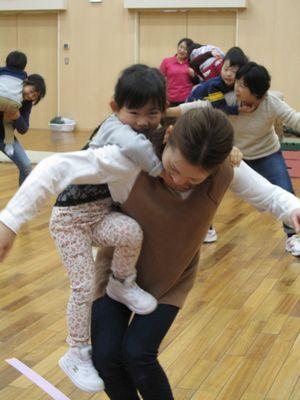 お母さんは両手を伸ばして子供が背中にしがみついている写真