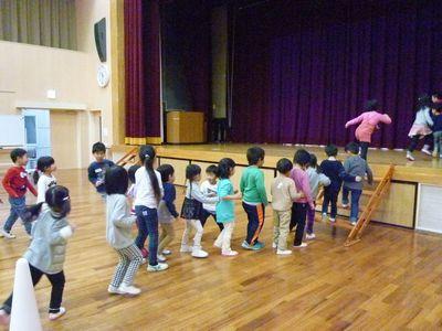 一列に並んで階段から舞台に上がっている子供たちの写真