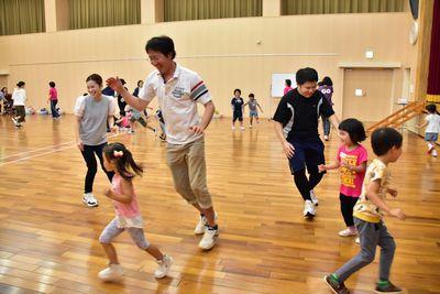 体育館の中で子供を追いかけて足りまわっている参加者の写真