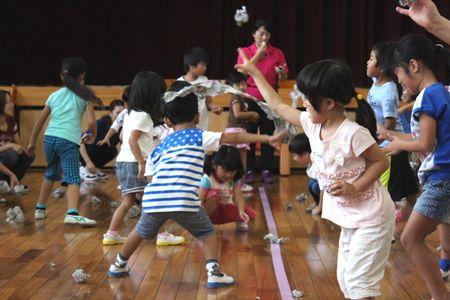 丸めた新聞紙を相手チームに向かって投げ込んでいる子供たちの写真