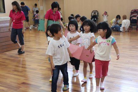 ピンク色の箱を運んでいる5人の子供たちの写真