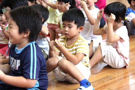 床に座って指遊びをしている子供たちの写真