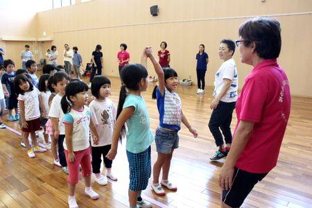 ペア同士で手をつないで並んでいる子供たちと女性スタッフの写真