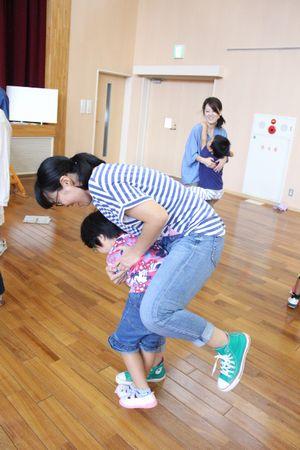 小さく折りたたんだ新聞紙の上に片足で立っている親子の写真