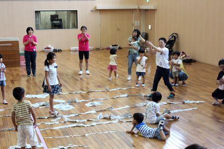 ちぎった新聞紙を床に並べて長さを比べている写真