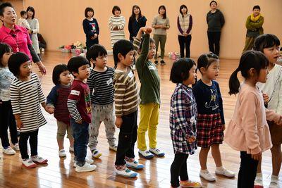 子供たちが2人組で手をつないで列を作り、前方の見ている写真