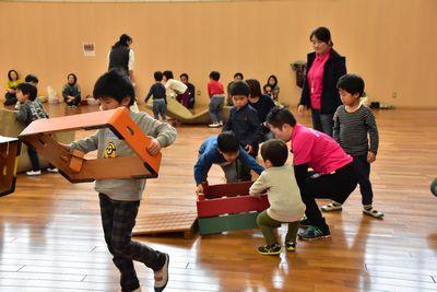 跳び箱を持って片づけをしている男の子たちの写真