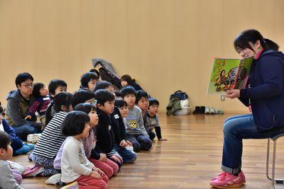 絵本の読み聞かせを聞いている子供たちの写真