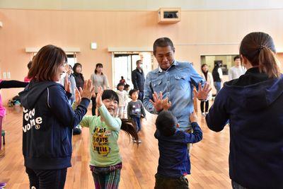 保護者と子供たちがハイタッチをしている写真