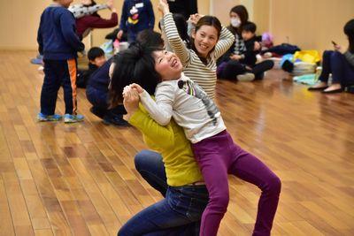 親子で背中通しをくっつけて手を伸ばし体を伸ばしている写真