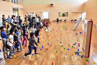 赤と青の鬼のボードに子供たちがボールを投げている写真