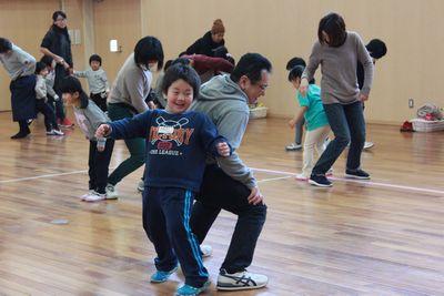 保護者と子供がペアになり背中で押し合っている写真