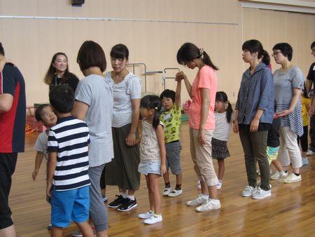 お母さんと子供たちが手をつないで1列に並んでいる写真