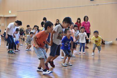 手をつないで、横に並びジャンプをしている子供たちの写真