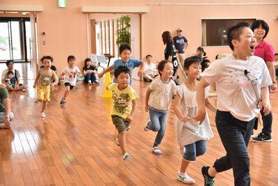 スタッフの方が走り出しスタッフの方の後を追いかけて子ども達が元気に走っている写真