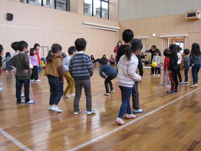 線の中にいる子供たちが、黄色いボールを持った女の子を見ている写真