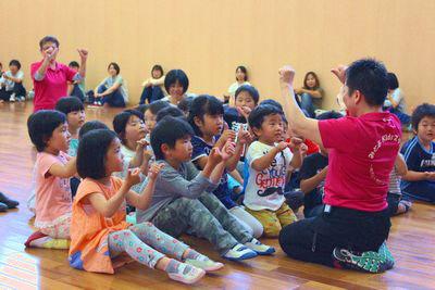 スタッフの人に合わせて手遊びをしている子供たちの写真