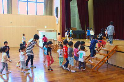 並んで右側の階段から舞台に上がり左側の階段から降りている子供たちの写真