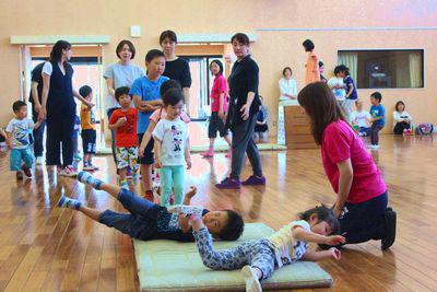 並んでマットの上を転げている子供たちの写真
