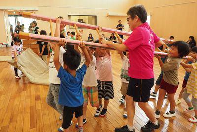 子供たちがみんなではしごを持って運んでいる写真