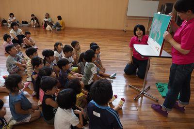 紙芝居を座って見ている子供たちの写真