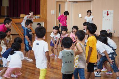 子供たちが円になって前かがみに構えている写真