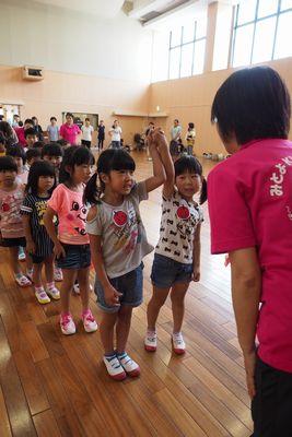 お友達とつないだ手を上にあげている女の子の写真