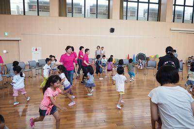 子供たちが一斉に円の中を椅子を目指して走っている写真