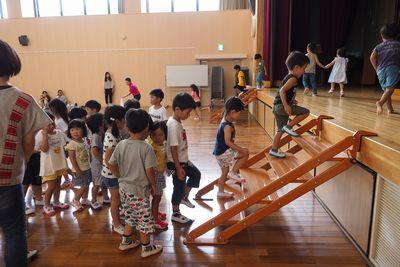子供たちが並んで右側の階段から舞台に上がり左側の階段から降りている写真