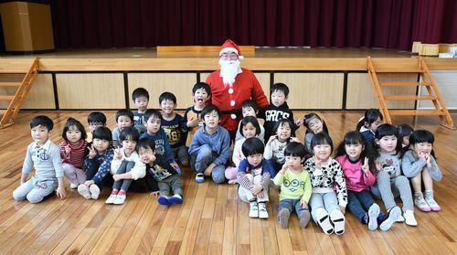サンタクロースの恰好をした男性を中心に子供たちが集まっている集合写真