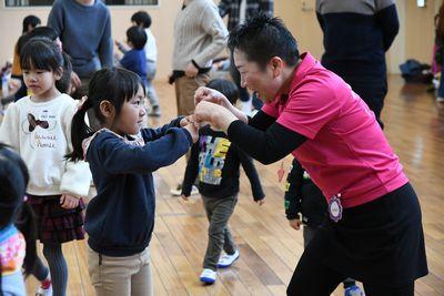 スタッフの女性とちいさな女の子が両手でこぶしを合わせてグータッチをしている写真