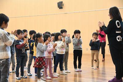 スタッフの周りに子供たちが集まっていて、みんなで手を合わせている写真