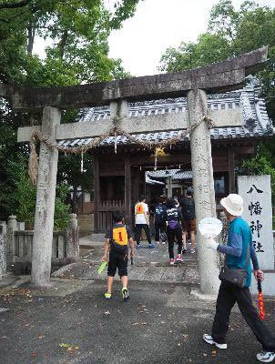 八幡神社の鳥居を通って、神社の中へ入って行く人の写真