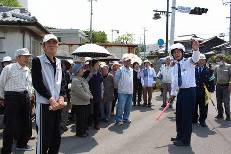 交差点に集まり警察官の説明を聞いている地域の皆さんの写真