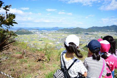 山頂からの景色を眺めている女の子たちの写真