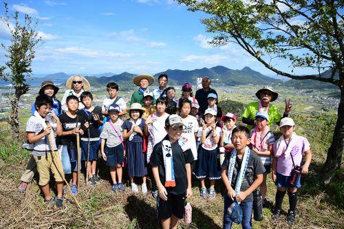 頂上で参加した子供たちが記念撮影をしている写真