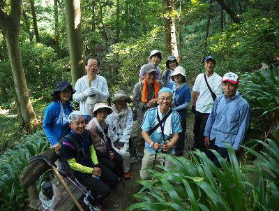 森の中で11名の参加者とガイドの方と一緒に笑顔で記念撮影写真